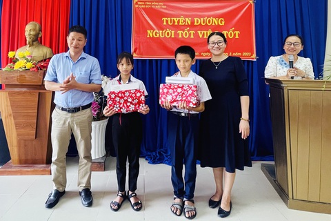 Khen thưởng đột xuất hai học sinh lớp 5 trả lại người đánh rơi hàng trăm triệu đồng - Ảnh 1. Phó giám đốc Sở Giáo dục và Đào tạo Đồng Nai Đỗ Đăng Bảo Linh (trái) trao thưởng cho hai em học sinh có hành động đẹp trả lại của rơi - Ảnh: MINH THƯ