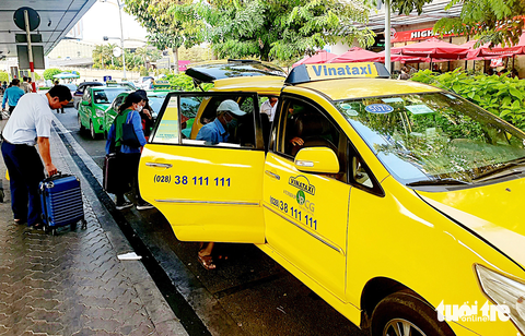 Khách đi taxi sân bay gánh thêm phí - Ảnh 2. Hành khách đón taxi tại làn C sân bay Tân Sơn Nhất vào chiều 22-3 - Ảnh: CÔNG TRUNG