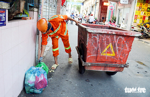 Thu thêm tiền vận chuyển rác, mong sớm hết nhếch nhác - Ảnh 2. Nhân viên thu gom rác tại hẻm 391 Trần Hưng Đạo, quận 1, TP.HCM - Ảnh: PHƯƠNG QUYÊN