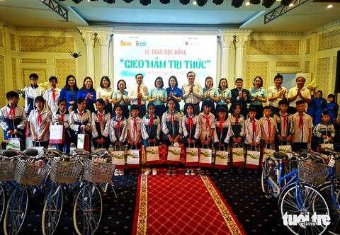 Tiếp sức cho học sinh nghèo Hải Dương - Ảnh 1. Bà Nguyễn Thị Sơn, phó giám đốc Agribank Phú Nhuận (thứ sáu từ trái qua) và ông Đinh Minh Trung, phó tổng biên tập báo Tuổi Trẻ (thứ tám từ trái qua) trao học bổng tại Hải Dương sáng 23-3 - Ảnh: VŨ TUẤN