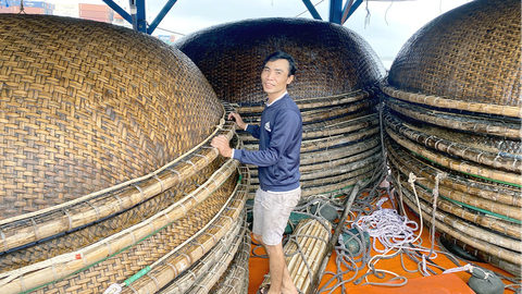 Can trường trên sóng gió đại dương - Kỳ 3: Truyền đời cỡi sóng gió Hoàng Sa, Trường Sa - Ảnh 1. Ngư dân Huỳnh Văn Việt chằng buộc lại giàn thúng câu mực trước giờ nhổ neo - Ảnh: B.D.