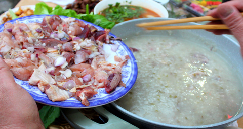 Lúc bắt đầu ăn thì cho thịt gà, lòng gà đã ướp vào nồi cháo đang sôi sùng sục Lúc bắt đầu ăn thì cho thịt gà, lòng gà đã ướp vào nồi cháo đang sôi sùng sục