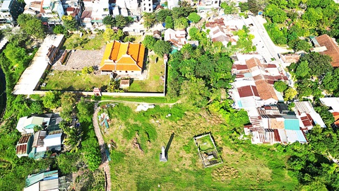 Sống khổ trong lăng mộ ba vua - Ảnh 1. An Lăng với khu chen chúc nhà tạm bợ của người dân (bên phải hình) trong di tích - Ảnh: TAM GIANG