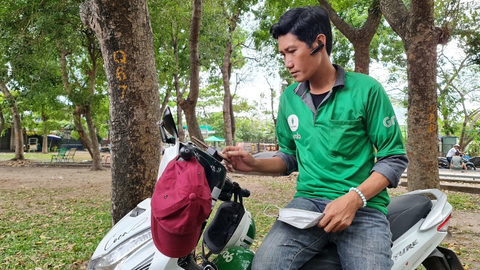 Người xây dựng lao đao: Tạm đổi nghề, lấy ngắn nuôi dài - Ảnh 1. Không có việc để theo nghề phụ hồ, Tô Hồng Thái chuyển sang chạy xe ôm công nghệ - Ảnh: C.TRIỆU