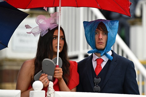 Người tham dự cuộc đua ngựa Grand National Festival sáng tạo khi mắc mưa tại Trường đua ngựa Aintree ở Liverpool, tây bắc nước Anh, vào ngày 14-4 - Ảnh: AFP Người tham dự cuộc đua ngựa Grand National Festival sáng tạo khi mắc mưa tại Trường đua ngựa Aintree ở Liverpool, tây bắc nước Anh, vào ngày 14-4 - Ảnh: AFP