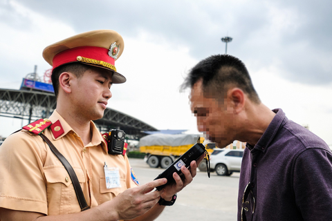 Một cán bộ cảnh sát giao thông hướng dẫn tài xế thổi nồng độ cồn trên quốc lộ 1A - Ảnh: NAM TRẦN Một cán bộ cảnh sát giao thông hướng dẫn tài xế thổi nồng độ cồn trên quốc lộ 1A - Ảnh: NAM TRẦN