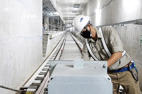 Nhìn thẳng nguyên nhân để vực dậy kinh tế TP.HCM - Ảnh 7. Công nhân thi công tuyến metro số 1 công trình đầu tư công chậm giải ngân - Ảnh: TỰ TRUNG
