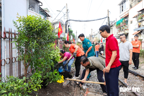 Quận Phú Nhuận hoàn thành đường hoa dọc tuyến đường sắt - Ảnh 1. Cán bộ công chức - viên chức, dân quân, nhân dân phường 4, quận Phú Nhuận dọn vệ sinh, trồng hoa dọc tuyến đường sắt qua địa bàn - Ảnh: T.B.T.