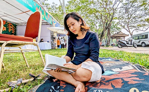 Bạn đọc chọn cho mình một góc xanh mát giữa bãi cỏ trước khuôn viên Quốc Tử Giám để đọc sách - Ảnh: NHẬT LINH Bạn đọc chọn cho mình một góc xanh mát giữa bãi cỏ trước khuôn viên Quốc Tử Giám để đọc sách - Ảnh: NHẬT LINH