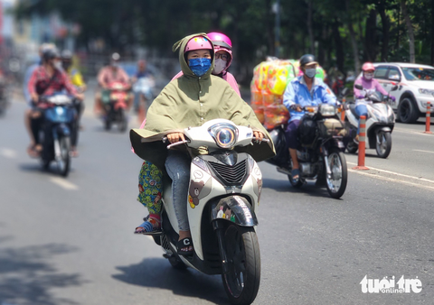 Nắng nóng oi bức, người dân TP.HCM tìm đủ cách hạ nhiệt - Ảnh 1. Người dân ra đường mặc áo kín mít - Ảnh: NGỌC KHẢI