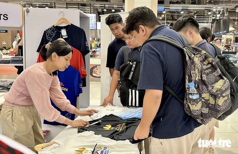 Chưa khai mạc, linh vật SEA Games 32 đã 'cháy hàng' - Ảnh 6. Một nhóm sinh viên Campuchia hỏi mua áo lưu niệm SEA Games 32 - Ảnh: N.K
