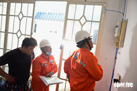 Giám sát chi phí của EVN ra sao? - Ảnh 6. Nhân viên điện lực Gò Vấp (TP.HCM) thay điện kế điện tử có tính năng đo chỉ số điện từ xa tại nhà dân - Ảnh: NGỌC PHƯỢNG