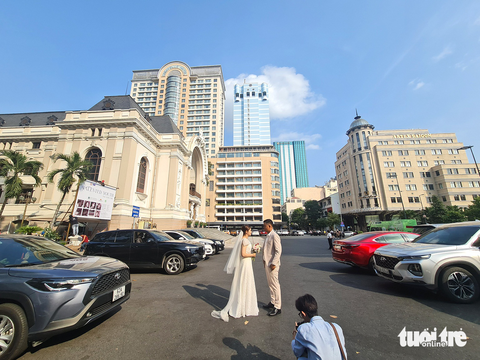 Lê Lợi, đại lộ tình yêu - Kỳ cuối: Đại lộ của khát vọng đổi thay- Ảnh 2. Đôi lứa chụp hình cưới lãng mạn trước Nhà hát TP.HCM đầu đường Lê Lợi - Ảnh: QUỐC VIỆT
