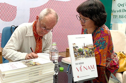 Du hành bằng trái tim - Ảnh 1. Tác giả Jean-Pierre Outers (trái) ký tặng sách Du hành về Nam tại Đường sách TP.HCM - Ảnh: KHẢ LINH