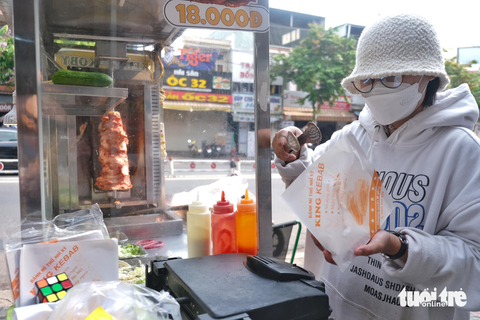 Những con đường san sát bánh mì ở Sài Gòn - Ảnh 9. Dạng xe bánh mì nhượng quyền còn tạo thêm được việc làm thêm cho các bạn sinh viên. Trong ảnh bạn Trang (sinh viên trường Đại học Công nghiệp TP.HCM) đang làm thêm - Ảnh: NGỌC PHƯỢNG