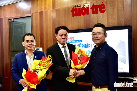 Đang giao lưu trực tuyến: Chú ý gì về pháp lý khi giao dịch bất động sản thời kỳ trầm lắng? - Ảnh 1. Ông Võ Minh Luận - thư ký tòa soạn báo Tuổi Trẻ (bìa phải) - tặng hoa cho khách mời giao lưu - Ảnh: T.T.D.