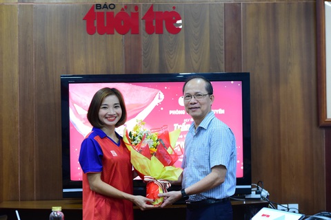 HLV Trần Văn Sỹ: 'Nguyễn Thị Oanh có ý chí thi đấu, trái tim sắt đá, bước chạy mạnh mẽ' - Ảnh 1. Nhà báo Lê Xuân Trung, phó tổng biên tập báo Tuổi Trẻ (phải) tặng hoa vận động viên điền kinh Nguyễn Thị Oanh - Ảnh: DUYÊN PHAN
