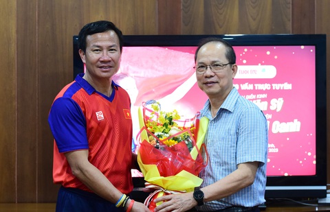 Nguyễn Thị Oanh và HLV Trần Văn Sỹ giao lưu trực tuyến cùng độc giả - Ảnh 1. Nhà báo Lê Xuân Trung, phó tổng biên tập báo Tuổi Trẻ (phải) tặng hoa chúc mừng HLV Trần Văn Sỹ - Ảnh: DUYÊN PHAN