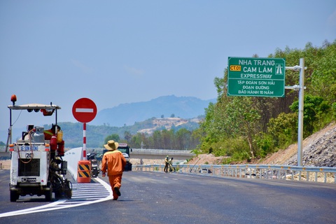 Chính thức thông xe cao tốc Nha Trang - Cam Lâm, vẫn còn xe máy chạy ngược chiều trên cao tốc - Ảnh 1. Tại điểm đầu vào cao tốc Nha Trang - Cam Lâm, công nhân vẫn còn thi công mặt đường - Ảnh: MINH CHIẾN