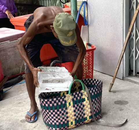 Ông Chau On chất những bẹ nước đá vào hai chiếc giỏ để gánh lên núi - Ảnh: DIỆU QUÍ Ông Chau On chất những bẹ nước đá vào hai chiếc giỏ để gánh lên núi - Ảnh: DIỆU QUÍ
