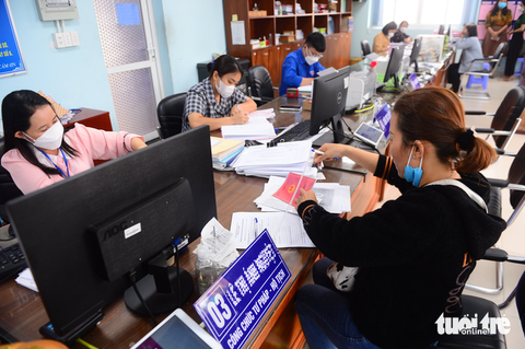 Đề xuất cán bộ không hẹn gặp, tiếp người dân ngoài trụ sở - Ảnh 1. Cán bộ tại TP.HCM phục vụ người dân đến làm thủ tục hành chính - Ảnh: QUANG ĐỊNH