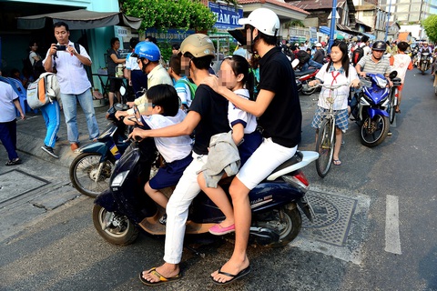 Trẻ ngồi trước xe máy, ô tô: Điều nguy hiểm nên cấm - Ảnh 2. Tình trạng để trẻ ngồi trước xe máy, không đội mũ bảo hiểm rất phổ biến và rất nguy hiểm - Ảnh: QUANG ĐỊNH