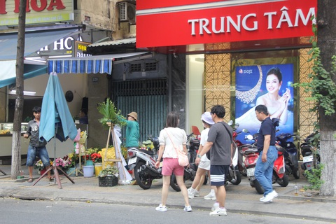 Vỉa hè cấm buôn bán ở Đà Nẵng vẫn tràn lan bàn ghế, khách đi xuống đường - Ảnh 4. Du khách phải đi xuống lòng đường do vỉa hè khu vực đường Trần Phú vừa bị lấn chiếm, vừa ken kín chỗ để xe