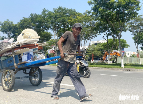 Đời kéo xe dưới nắng nóng đổ lửa - Ảnh 1. Giữa trưa nắng bỏng rát, ông Tý vẫn lầm lụi kéo từng cuốc xe lôi - Ảnh: B.D