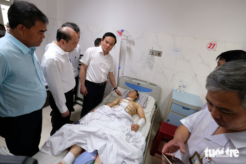 Phó thủ tướng Trần Lưu Quang thăm hỏi nạn nhân vụ 2 trụ sở UBND xã bị tấn công - Ảnh 3. Phó thủ tướng động viên thượng úy Đàm Đình Bốp (30 tuổi), phó trưởng Công an xã Ea Ktur - nạn nhân trong vụ hai trụ sở UBND xã bị tấn công - Ảnh: MAI VINH