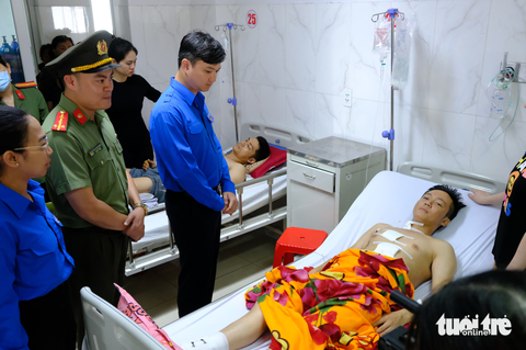 Tặng huy hiệu Tuổi trẻ dũng cảm cho 5 chiến sĩ công an trong vụ trụ sở xã ở Đắk Lắk bị tấn công - Ảnh 4. Anh Nguyễn Minh Triết thăm hỏi, động viên, trao huy hiệu Tuổi trẻ dũng cảm cho hai chiến sĩ công an bị trọng thương tại bệnh viện là anh Đàm Đình Bốp và anh Lê Kiên Cường - Ảnh: ĐÌNH CƯƠNG