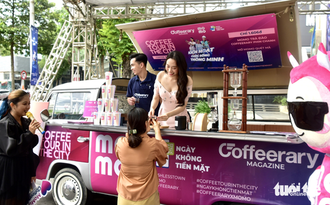 Khách đến lễ hội Không tiền mặt đông nghẹt, ngân hàng mở thêm giải thưởng trúng vàng và xe - Ảnh 8. Đại diện Momo cho biết đã phát ra hàng nghìn phần quà từ 16-6 đến chiều 17-6. Trong ảnh: khách đến gian hàng Momo để trải nghiệm và nhận quà từ hoa hậu - Ảnh: T.T.D