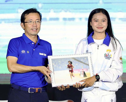 Phó tổng biên tập báo Tuổi Trẻ Trần Xuân Toàn trao tấm hình Bou Samnang chạy dưới mưa ở SEA Games 32 để làm kỷ niệm tại buổi giao lưu - Ảnh: N.K. Phó tổng biên tập báo Tuổi Trẻ Trần Xuân Toàn trao tấm hình Bou Samnang chạy dưới mưa ở SEA Games 32 để làm kỷ niệm tại buổi giao lưu - Ảnh: N.K.
