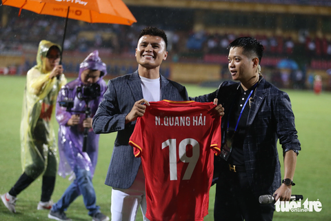 CĐV đội mưa xem Quang Hải ra mắt đội Công An Hà Nội - Ảnh 8. Cựu cầu thủ Pau FC khoe chiếc áo số 19 mà anh sẽ mặc tại CLB Công An Hà Nội - Ảnh: ĐỨC KHUÊ