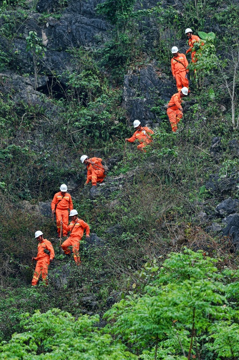 Vượt núi, băng rừng "cõng" điện lên vùng biên ải - Ảnh 1. Công nhân Điện lực huyện Yên Minh băng rừng khảo sát kéo dây điện cho bà con vùng biên ải