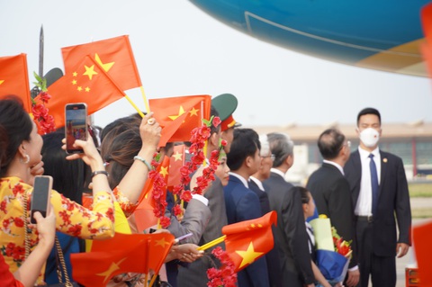 Cờ hoa rực rỡ chào đón Thủ tướng Phạm Minh Chính tới Trung Quốc - Ảnh 3. Quốc kỳ hai nước được đông đảo cộng đồng người Việt tại Trung Quốc, cán bộ đại sứ quán vẫy chào đón Thủ tướng - Ảnh: NGỌC AN