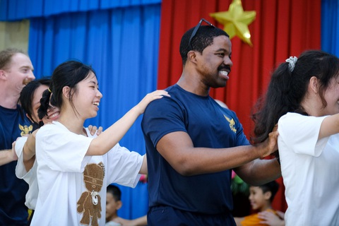 - Ảnh 9. Các thành viên hai bên quàng vai nhau chạy vòng tròn hòa thêm âm nhạc - Ảnh: TẤN LỰC