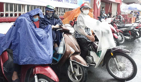 Phụ huynh đội mưa chờ thí sinh tại điểm thi trường THCS College Q3, TPHCM trong buổi nghe qui chế thi. Ảnh: NHƯ HÙNG Phụ huynh đội mưa chờ thí sinh tại điểm thi trường THCS Colette, quận 3 chiều 27-6 - Ảnh: NHƯ HÙNG