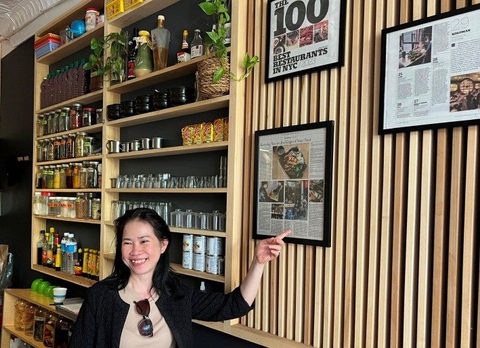 Bún đậu mắm tôm trên phố New York - Ảnh 2. Một nữ du khách Việt hào hứng bên “bức tường thành tích” của Mắm - Ảnh: D.TRƯỜNG