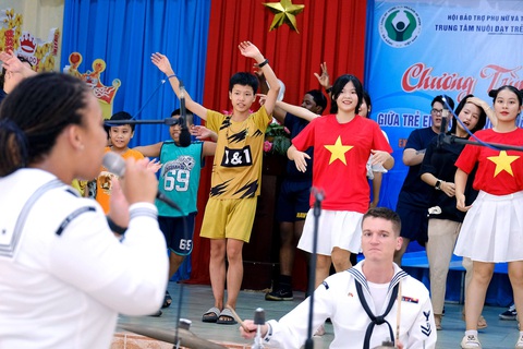 Tàu sân bay Mỹ gửi thông điệp hữu nghị - Ảnh 1. Ban nhạc hải quân Mỹ giao lưu cùng các em tại Làng Hy vọng, TP Đà Nẵng vào ngày 26-6 - Ảnh: TẤN LỰC