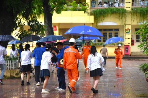 Những tình nguyện viên áo cam sẵn sàng hỗ trợ thí sinh di chuyển vào trường dưới cơn mưa Những tình nguyện viên áo cam sẵn sàng hỗ trợ thí sinh di chuyển vào trường dưới cơn mưa