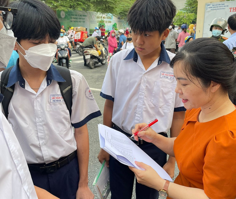 Cô hồng Mơ, Trường THCS Lê Văn Tám, quận Bình Thạnh đang điểm danh học sinh của mình tại cổng trường - Ảnh: LIÊN CHI Cô Hồng Mơ, Trường THCS Lê Văn Tám, quận Bình Thạnh đang điểm danh học sinh tại cổng trường - Ảnh: LIÊN CHI