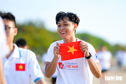 Lần đầu tiên trên đảo Trường Sa lớn, hàng trăm sinh viên cùng chạy 'Vì Trường Sa thân yêu' - Ảnh 6. Một bạn sinh viên cầm trên tay lá cờ Tổ quốc khi chuẩn bị chạy về đích