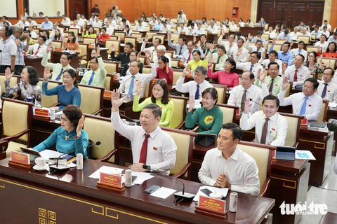TPHCM chi 1.500 tỉ xây công viên, trường học tại khu nghĩa trang Bình Hưng Hòa - Ảnh 1. Các đại biểu biểu quyết thông qua chương trình kỳ họp - Ảnh: HỮU HẠNH