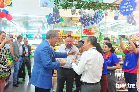 Thống đốc bang của Mỹ đi siêu thị tìm hiểu thị hiếu người Việt - Ảnh 2. Thống đốc bang Nebraska thích thú thử vị sầu riêng Việt Nam - Ảnh: N.BÌNH