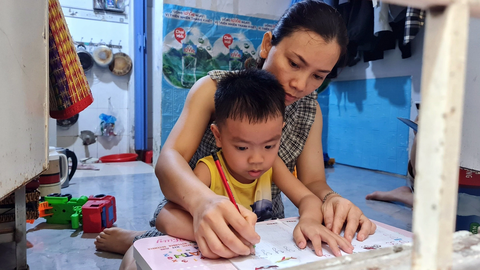 Chật vật vượt khó thời thất nghiệp - Ảnh 1. Thất nghiệp, chị Trần Thị Lâm dạy cậu út Lành học chữ tại phòng trọ thay vì cho con đi học thêm - Ảnh: CÔNG TRIỆU