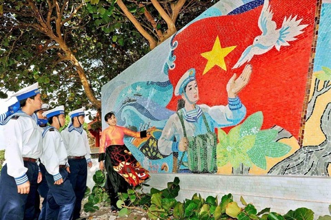Tôi gửi hồn vào lá cờ Tổ quốc giữa Trường Sa - Ảnh 4. Họa sĩ Thu Thủy cùng các chiến sĩ Trường Sa bên bức tranh gốm ở cột mốc chủ quyền ở trung tâm đảo Trường Sa Lớn - Ảnh: NVCC