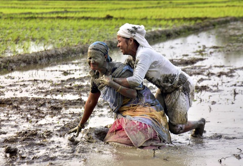 Hai người phụ nữ đùa vui với bùn sau khi cấy xong trên cánh đồng ở làng Uttarpara, huyện Baksa, bang Assam miền đông bắc Ấn Độ - Ảnh: DECCAN HERALD Hai người phụ nữ đùa vui với bùn sau khi cấy xong trên cánh đồng ở làng Uttarpara, huyện Baksa, bang Assam miền đông bắc Ấn Độ - Ảnh: DECCAN HERALD