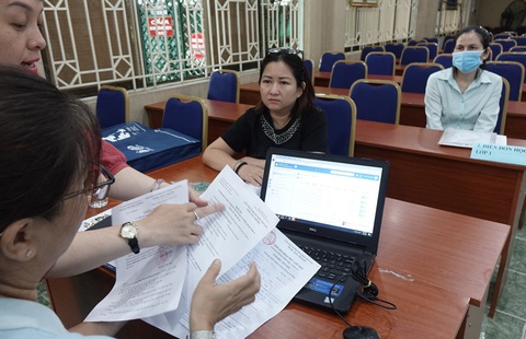 Phụ huynh trực tiếp nộp hồ sơ cho con vào lớp 1 sau khi đăng ký trực tuyến - Ảnh: ANH KHÔI Phụ huynh trực tiếp nộp hồ sơ cho con vào lớp 1 sau khi đăng ký trực tuyến - Ảnh: ANH KHÔI