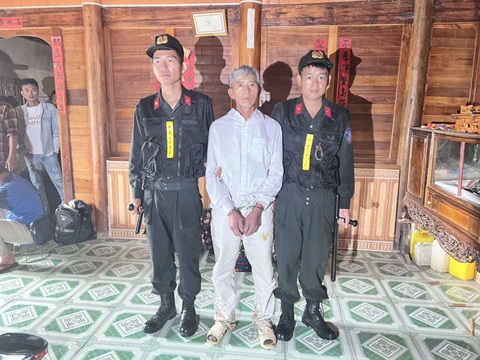 Bắt khẩn cấp người đàn ông dùng búa đinh sát hại cụ bà 73 tuổi tại ngôi nhà gỗ - Ảnh 1. Tẩn Yêu Hò (áo trắng) bị lực lượng công an bắt giữ sáng 13-7 - Ảnh: Công an tỉnh Lai Châu