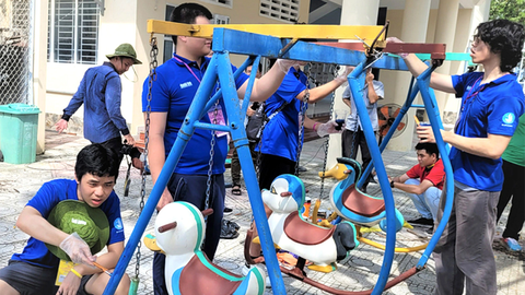 Về và thấy một Việt Nam rất khác - Ảnh 1. Các trại sinh kiều bào cùng sơn sửa khu vui chơi cho học sinh trong trường học tại xã đảo Thạnh An, huyện Cần Giờ (TP.HCM) - Ảnh: B.M.